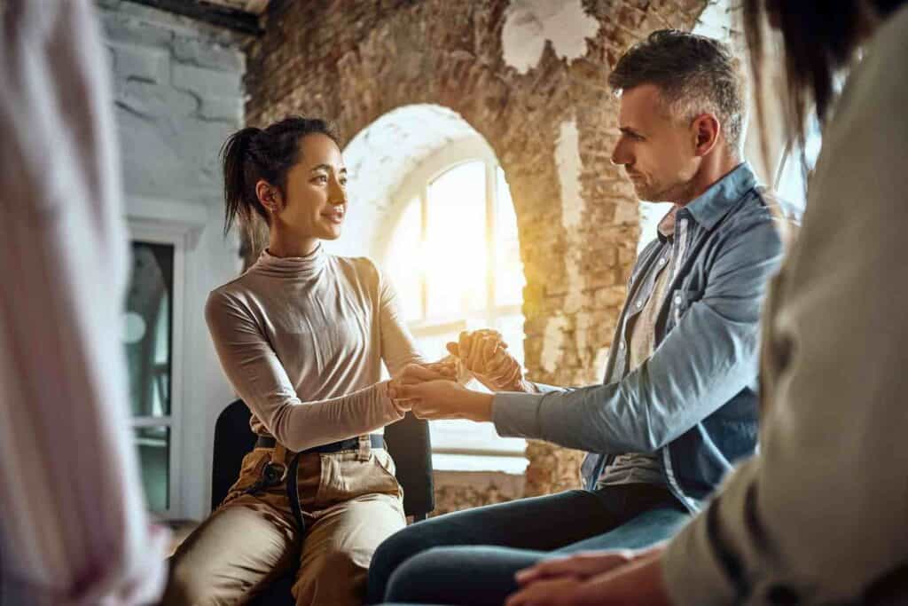 What Happens During The First 72 Hours Of Rehab? 1 Two people holding hands during a therapy session in addiction recovery