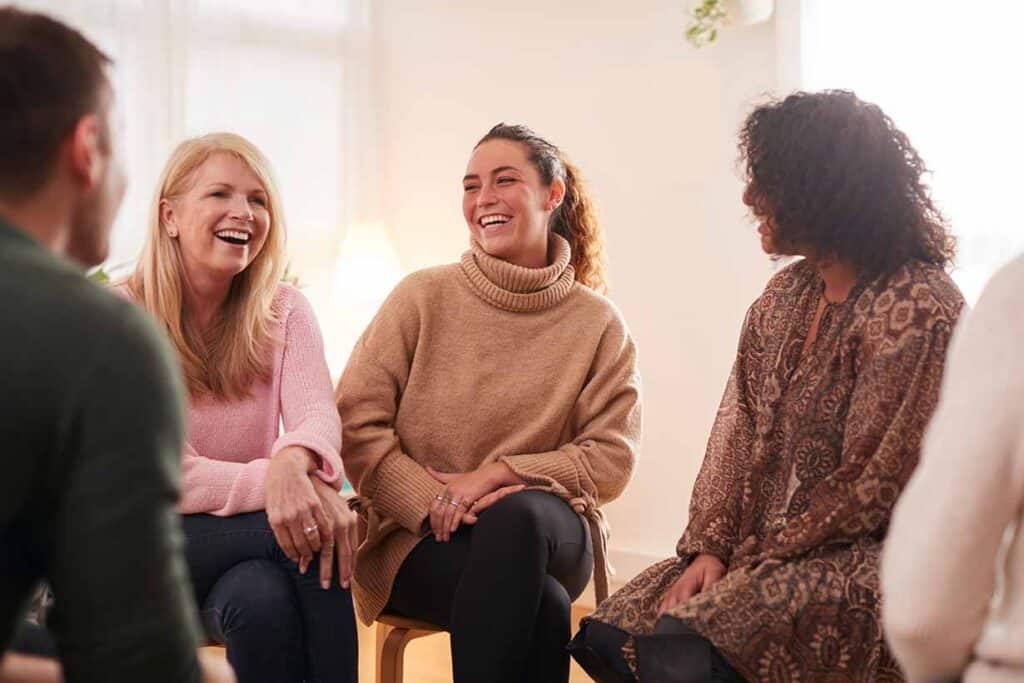 Women in addiction treatement smiling and laughing