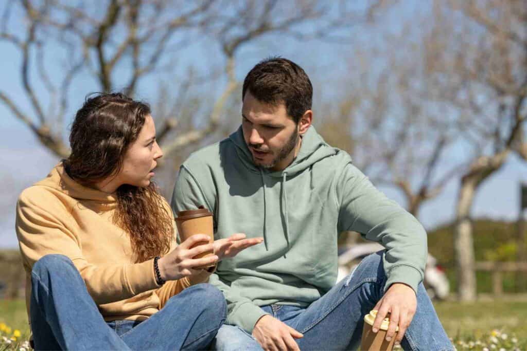 Two adults having a serious outdoor conversation about addiction treatment and the importance of seeking professional rehab support.