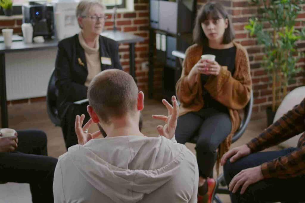 Participants engaging in a Dialectical Behavior Therapy (DBT) group skills training session led by a mental health professional.