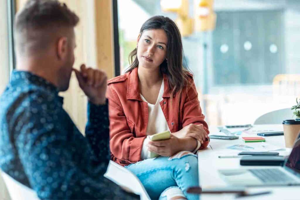 An addiction counselor listening attentively to a client during a private counseling session about substance use recovery.