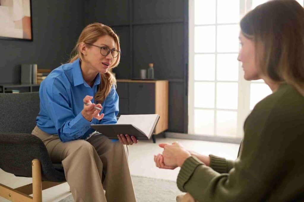 A therapist speaking compassionately with a family member about helping a loved one receive addiction treatment.
