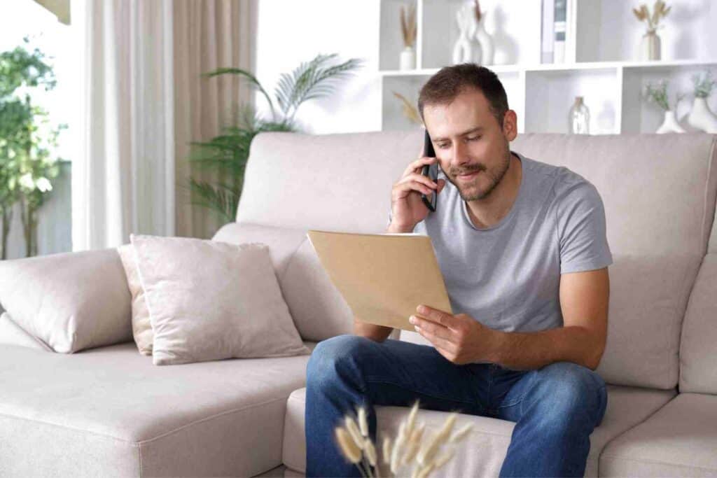 Man reviewing rehab payment information while speaking with an addiction treatment admissions team