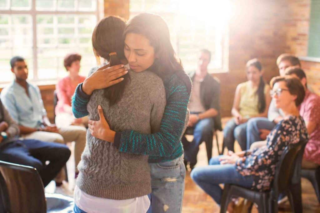 Signs You Need Medical Detox Before Rehab 1 People hugging during group therapy session for addiction recovery and medical detox support