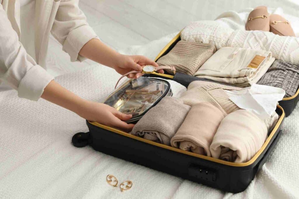Person packing toiletries, clothing, and personal essentials into a suitcase before entering an inpatient rehab program.