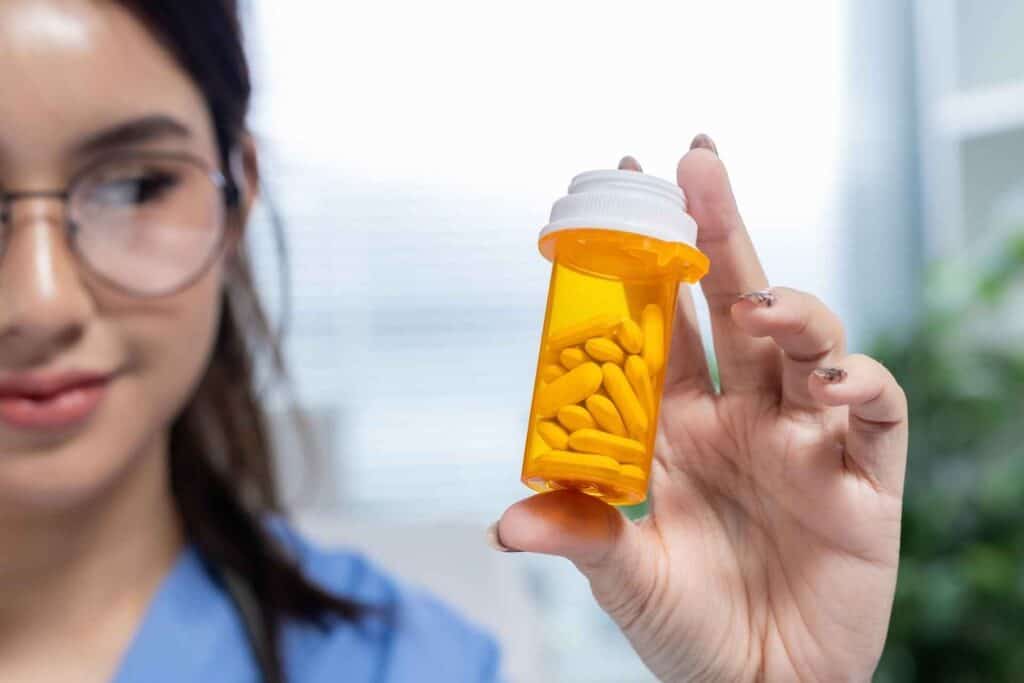 Medical professional holding a prescription bottle during medically supervised prescription drug detox.
